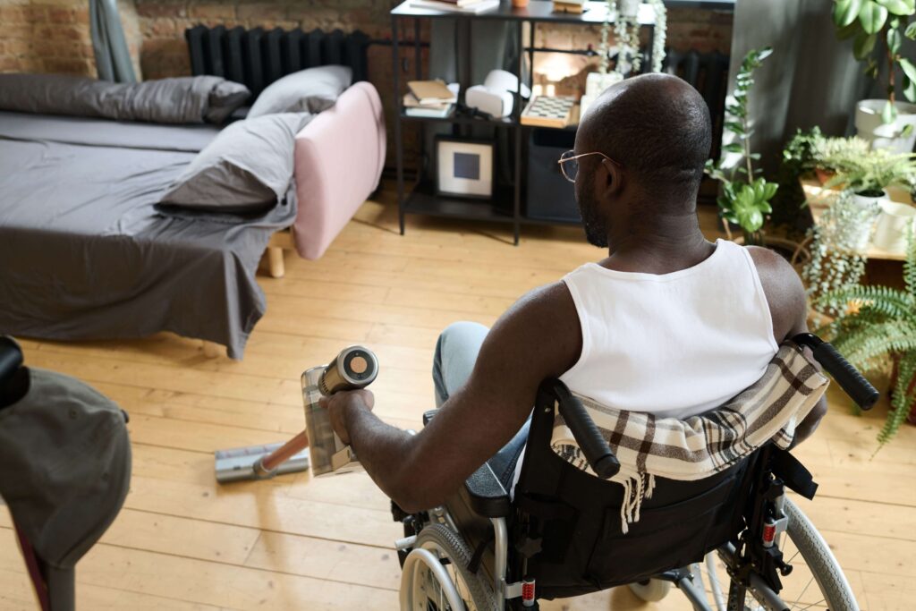 disabled man cleaning his room with daily tasks shared living and Accommodation Tenancy | NDIS near me