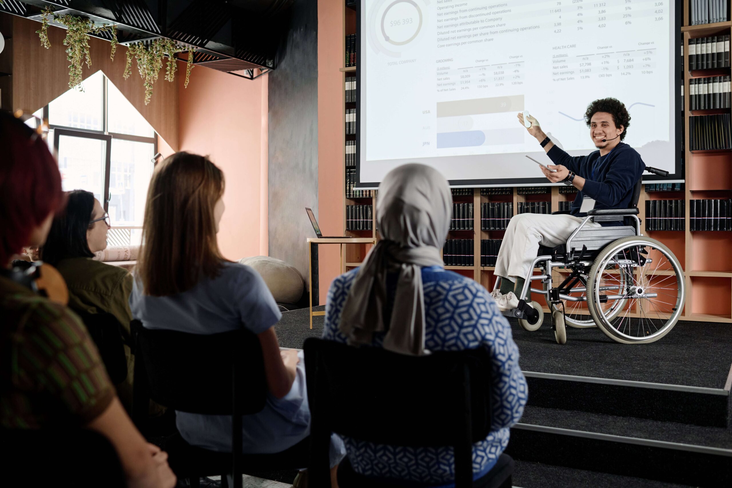 woman in wheelchair talks with group centre activities
