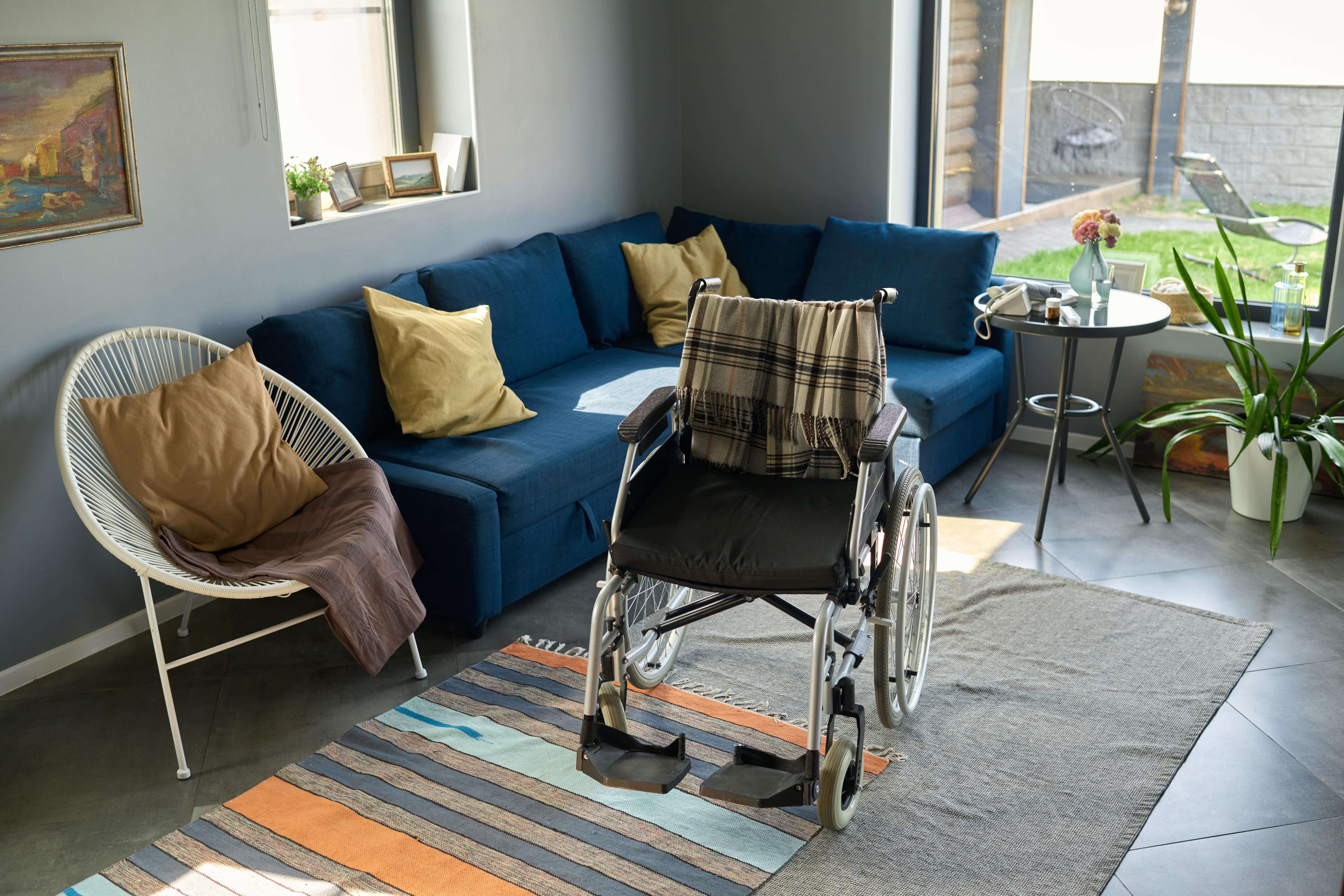 Accommodation Tenancy | wheelchair with grey woolen plaid standing in the living room with in home support and in home support